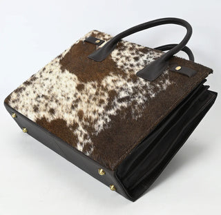 Handbag with brown and white cowhide pattern.
