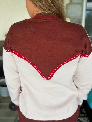 Back view of a person wearing a maroon and white sweater with red stitching.